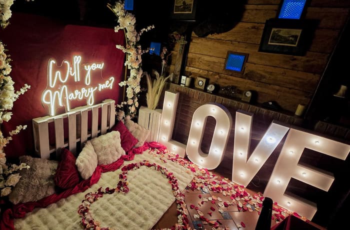 Montaje de pedida de mano con letrero de neón y pétalos