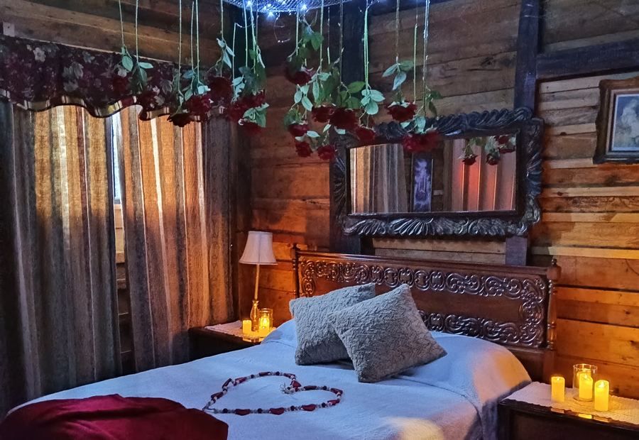Habitación de la cabaña decorada de noche con velas y rosas