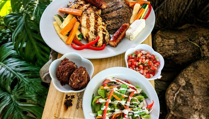 Plato de carnes a la parrilla con ensalada y guarniciones
